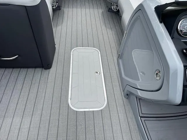 Slide: The Image of 2024 Godfrey Monaco 235 SB boat interior with sleek gray flooring and storage hatch. - 13