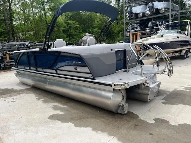 Slide: The Image of 2024 Godfrey Monaco 235 SB pontoon boat with sleek design, docked outdoors. - 4