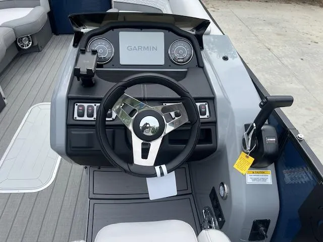Slide: The Image of 2024 Godfrey Monaco 235 SB boat dashboard with Garmin display and steering wheel. - 8