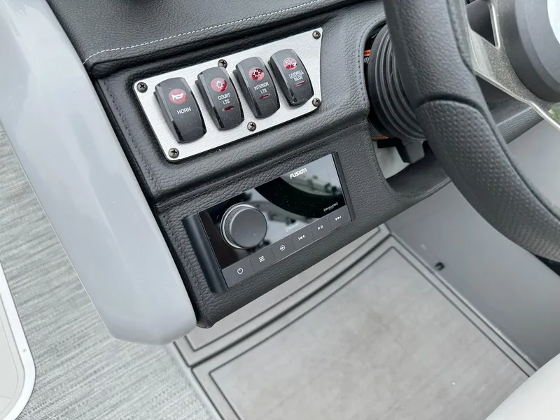 Slide: The Image of Control panel of 2024 Godfrey Monaco 235 SB boat with switches and audio system. - 15