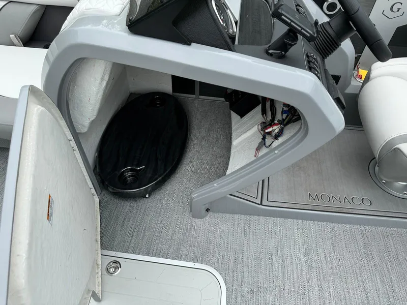 Slide: The Image of 2024 Godfrey Monaco 235 SB boat interior with steering console and seating area. - 16