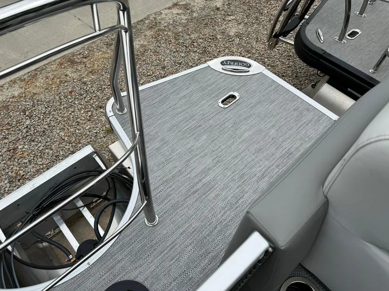 Slide: The Image of 2024 Godfrey Monaco 235 SB boat deck with sleek gray flooring and stainless steel railings. - 20