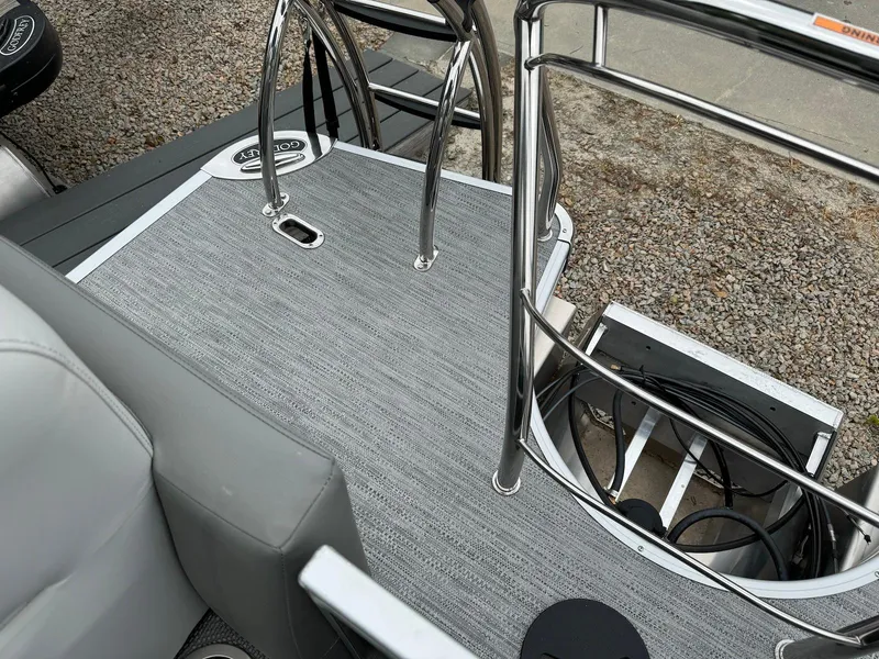 Slide: The Image of 2024 Godfrey Monaco 235 SB boat deck with sleek gray flooring and chrome railings. - 21