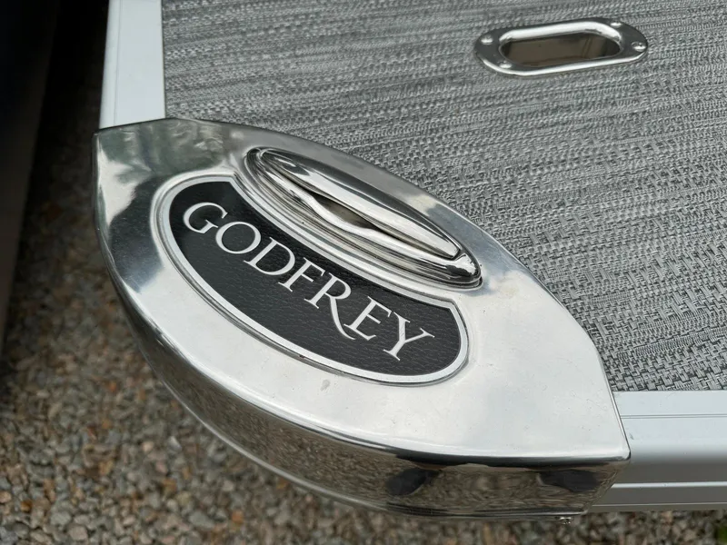 Slide: The Image of 2024 Godfrey Monaco 235 SB boat detail with logo on metallic surface. - 22