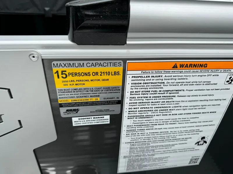 Slide: The Image of 2024 Godfrey Monaco 235 SB capacity and safety warning labels, maximum 15 persons or 2110 lbs. - 24