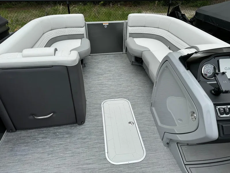 Slide: The Image of 2024 Godfrey Monaco 235 SB boat interior with gray seating and modern dashboard. - 8