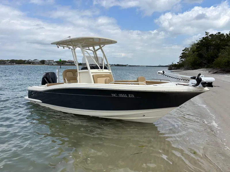 Slide: The Image of 2021 Scout 215XSF boat docked on sandy beach with clear skies. - 0