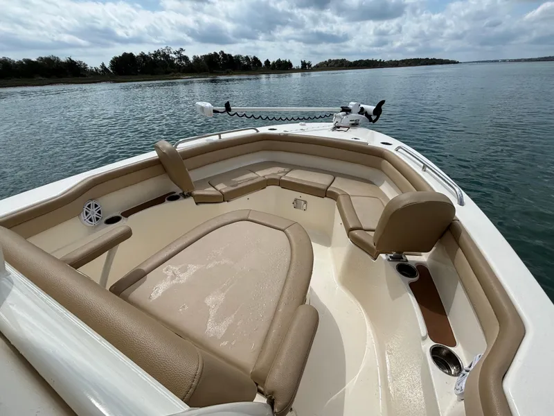 Slide: The Image of 2021 Scout 215XSF boat interior with tan seating on calm water. - 11