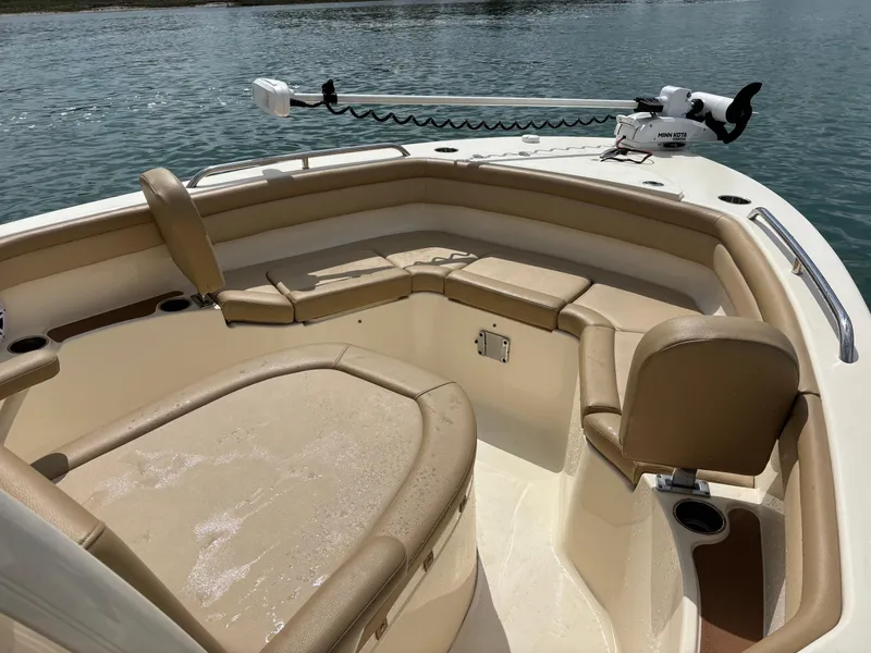 Slide: The Image of 2021 Scout 215XSF boat interior with tan seating and Minn Kota trolling motor. - 13