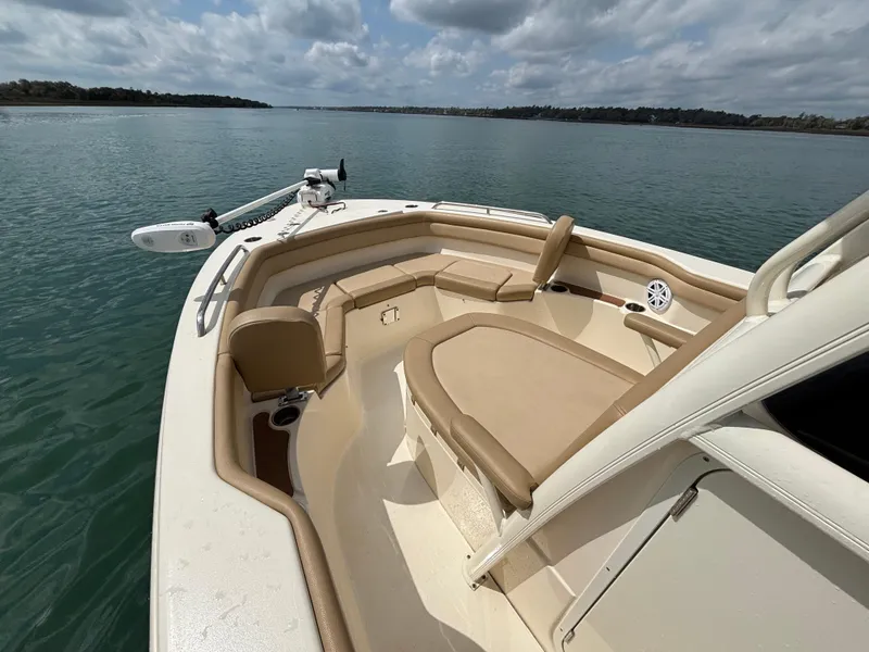 Slide: The Image of 2021 Scout 215XSF boat interior with seating, on calm water under cloudy sky. - 15