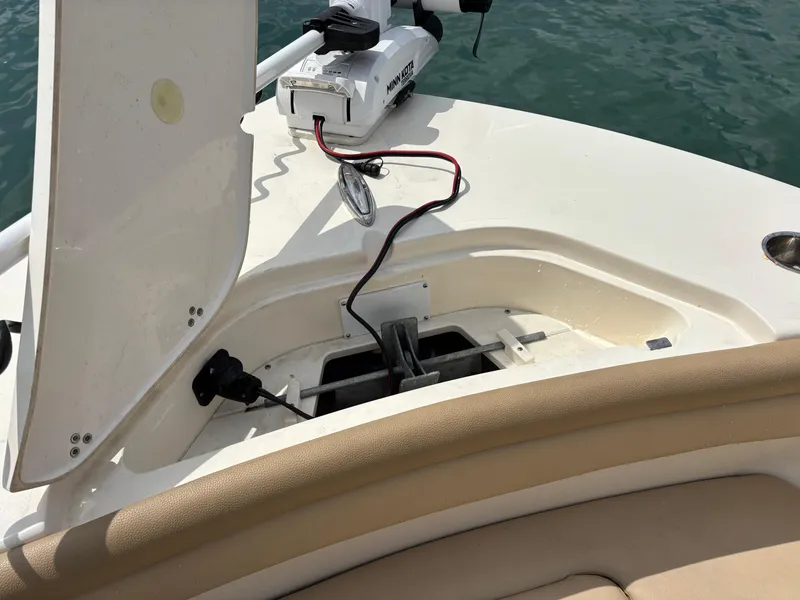 Slide: The Image of 2021 Scout 215XSF boat with open storage compartment and trolling motor. - 17