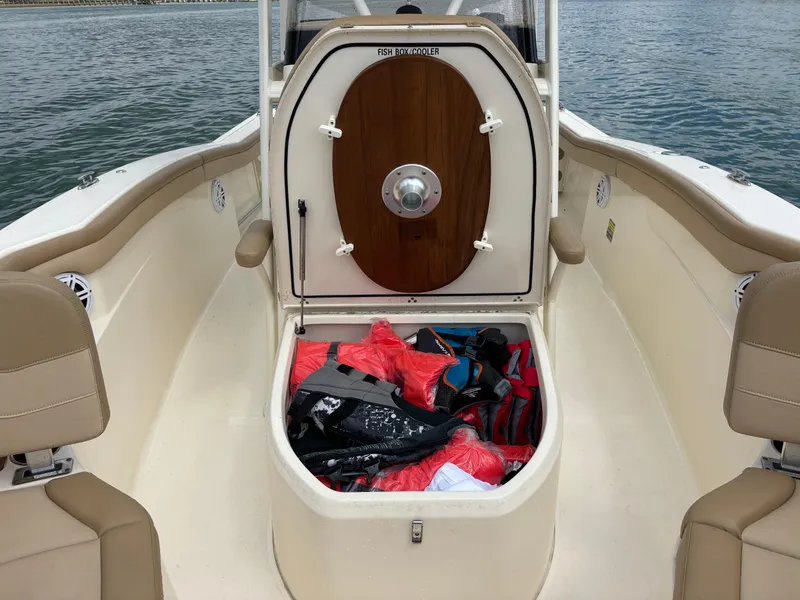 Slide: The Image of 2021 Scout 215XSF boat with open storage compartment, life jackets visible. - 21