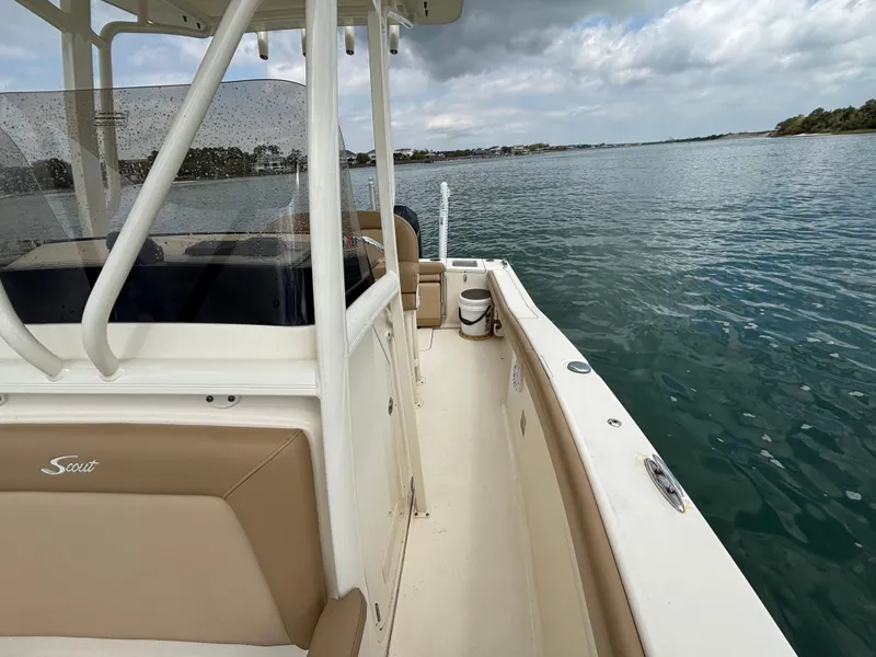 Slide: The Image of 2021 Scout 215XSF boat on calm water, featuring sleek design and spacious deck. - 23