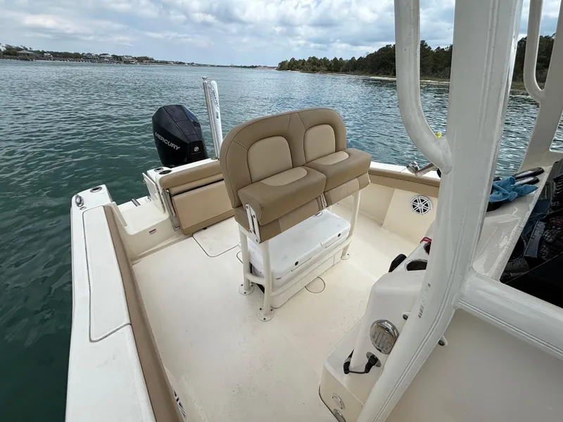 Slide: The Image of 2021 Scout 215XSF boat interior with seating and Mercury engine on calm water. - 25