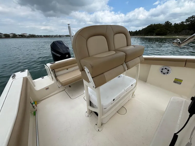 Slide: The Image of 2021 Scout 215XSF boat interior with seating and Mercury outboard motor on a calm lake. - 28