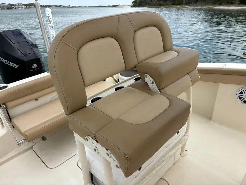 Slide: The Image of 2021 Scout 215XSF boat with tan seating and Mercury engine on calm water. - 29