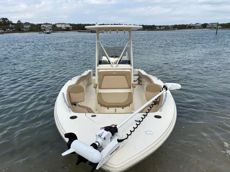 Slide: The Image of 2021 Scout 215XSF boat on calm water, featuring a sleek design and comfortable seating. - 3