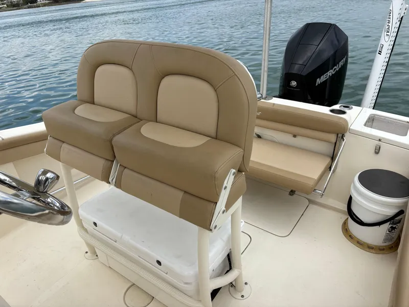 Slide: The Image of 2021 Scout 215XSF boat interior with tan seating and Mercury outboard motor. - 30