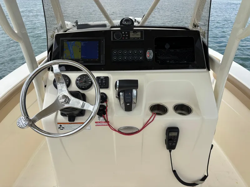 Slide: The Image of 2021 Scout 215XSF boat console with steering wheel, navigation system, and controls. - 38
