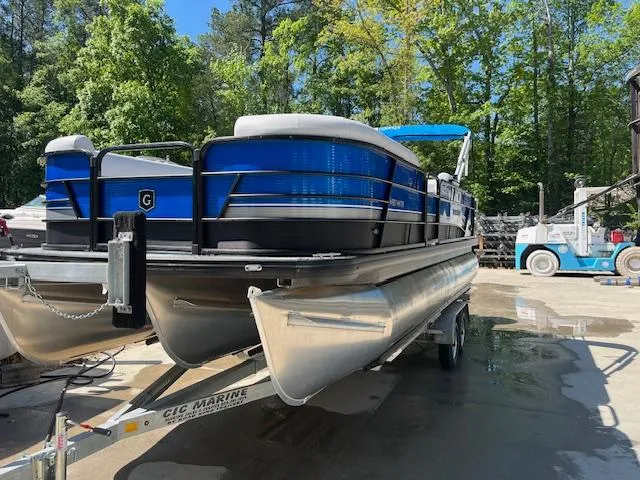 Slide: The Image of 2023 Godfrey SWEETWATER 2286 SFL pontoon boat on trailer, surrounded by trees. - 5