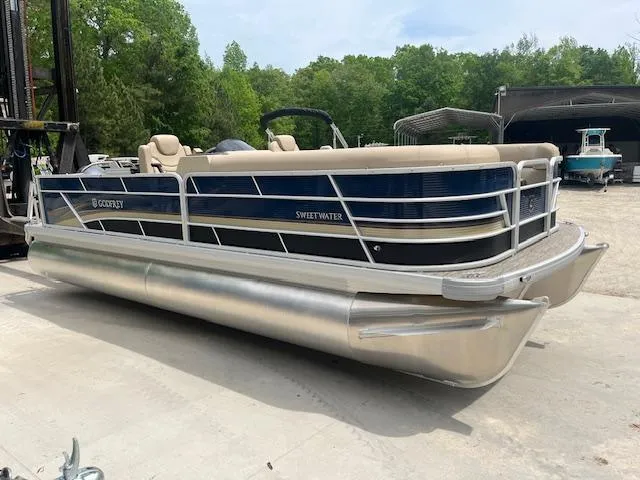 Slide: The Image of 2023 Godfrey SWEETWATER 2286 SFL pontoon boat on display outdoors. - 2