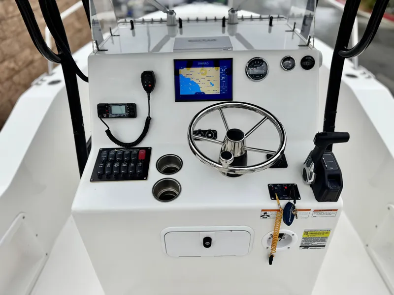 Slide: The Image of 2022 Thresher 25 CC boat console with steering wheel, navigation screen, and controls. - 27