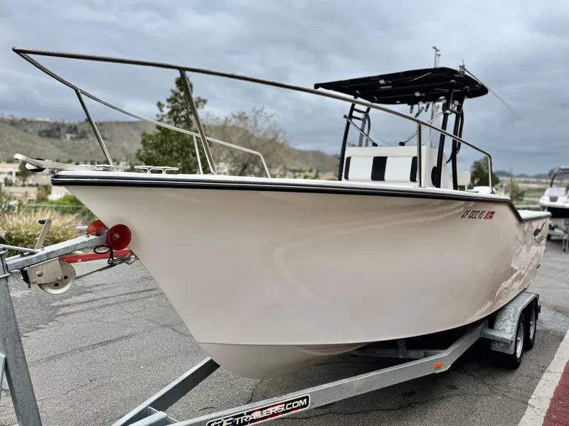 Slide: The Image of 2022 Thresher 25 CC boat on trailer, parked outdoors under cloudy sky. - 3