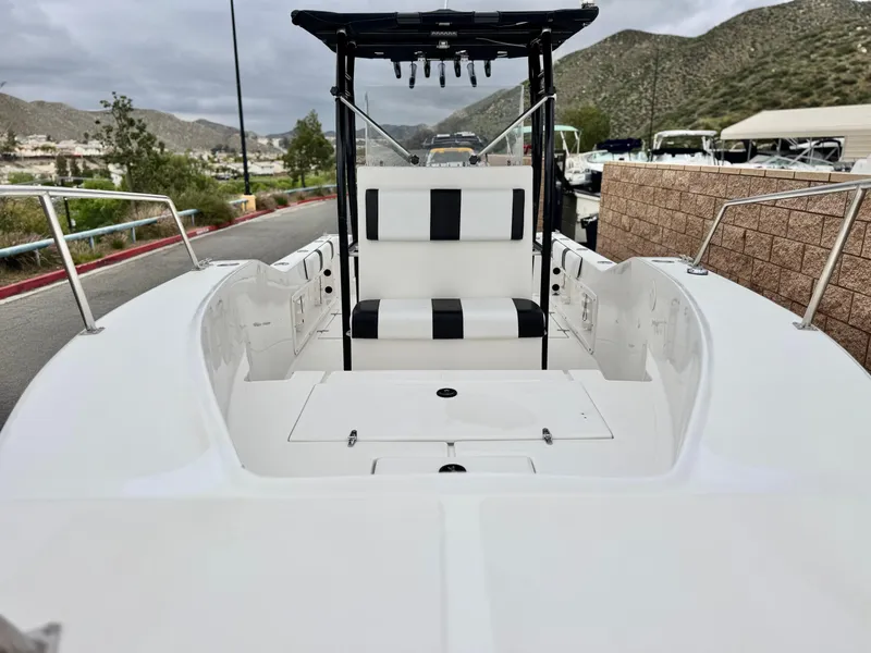 Slide: The Image of 2022 Thresher 25 CC boat with sleek white interior and black accents, docked near mountains. - 8