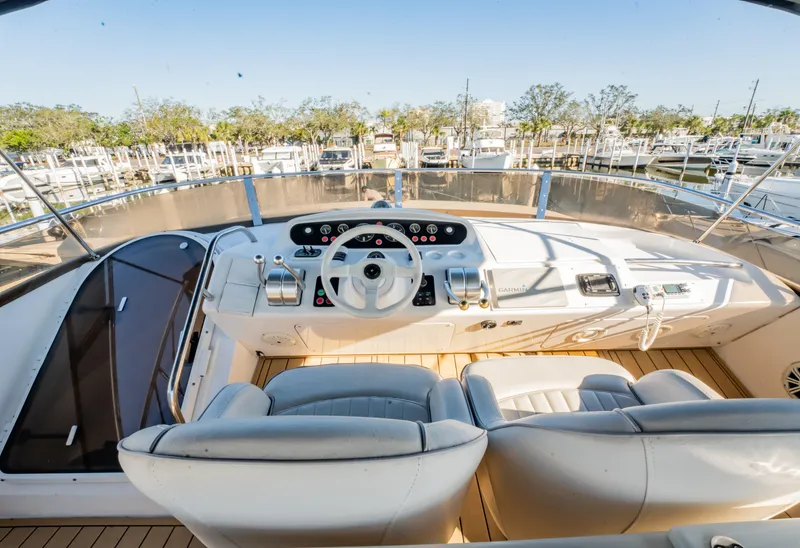 Slide: The Image of 1997 Viking Princess 60 Flybridge yacht helm with dual seats and marina view. - 13