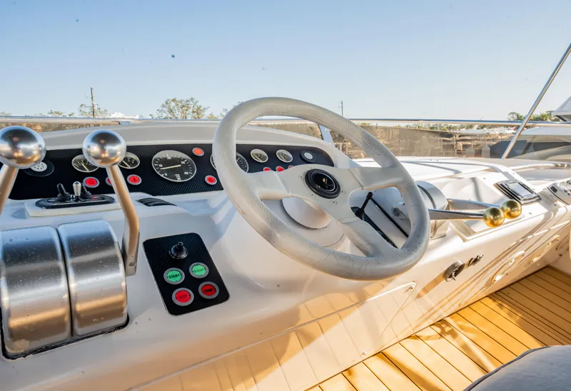 Slide: The Image of 1997 Viking Princess 60 Flybridge helm with steering wheel and control panel. - 14