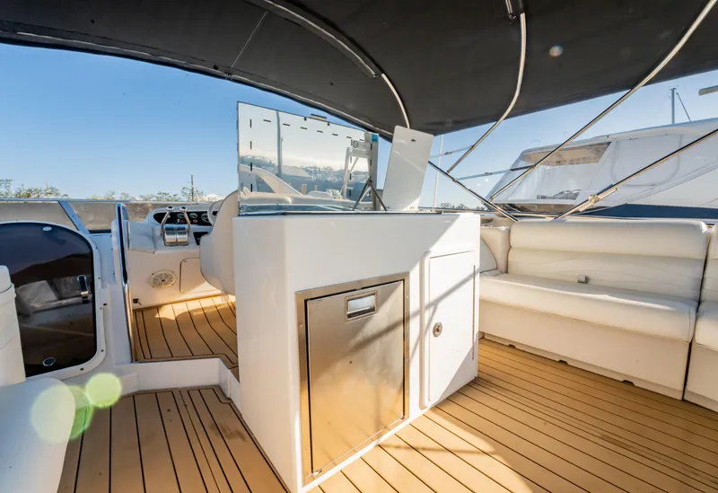 Slide: The Image of 1997 Viking Princess 60 Flybridge yacht interior with seating and helm, featuring teak flooring. - 16