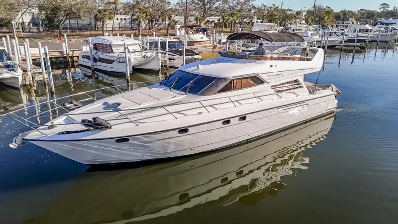 Slide: The Image of 1997 Viking Princess 60 Flybridge yacht docked in a marina, reflecting on calm water. - 2