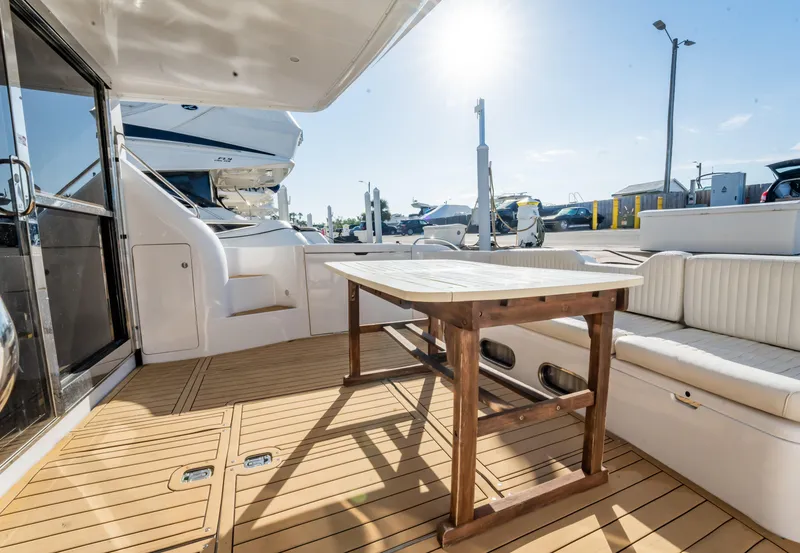 Slide: The Image of Luxurious 1997 Viking Princess 60 Flybridge yacht with spacious outdoor seating and wooden table. - 20