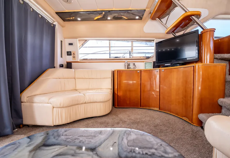 Slide: The Image of Luxurious interior of 1997 Viking Princess 60 Flybridge yacht with plush seating and TV. - 22