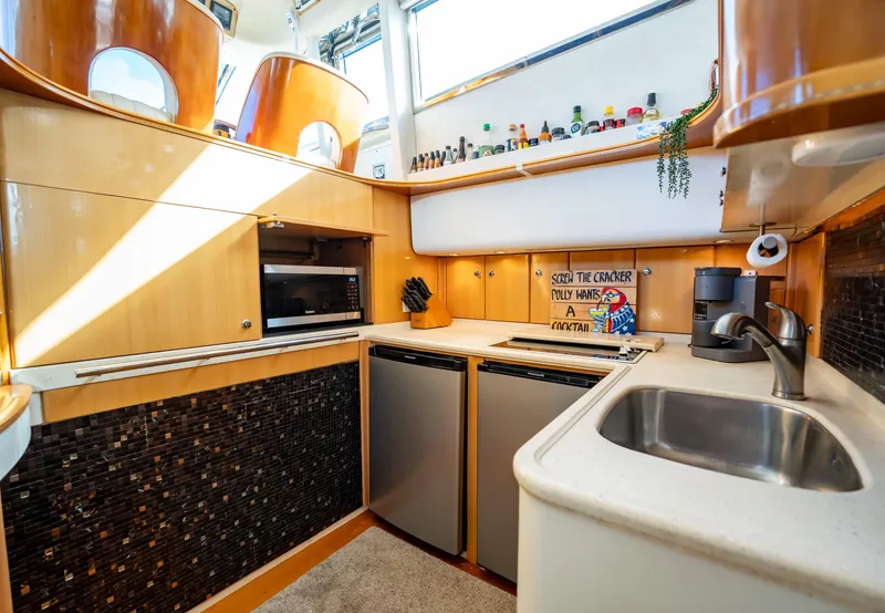 Slide: The Image of 1997 Viking Princess 60 Flybridge yacht kitchen with modern appliances and stylish wood cabinetry. - 29