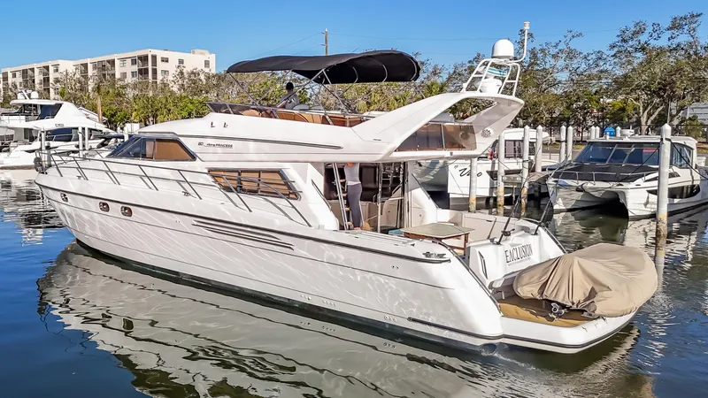 Slide: The Image of 1997 Viking Princess 60 Flybridge yacht docked in a marina, reflecting on calm water. - 3