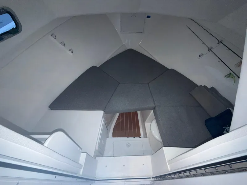 Slide: The Image of 2024 Steiger Craft 28 Peconic cabin interior with cushioned seating and storage. - 13