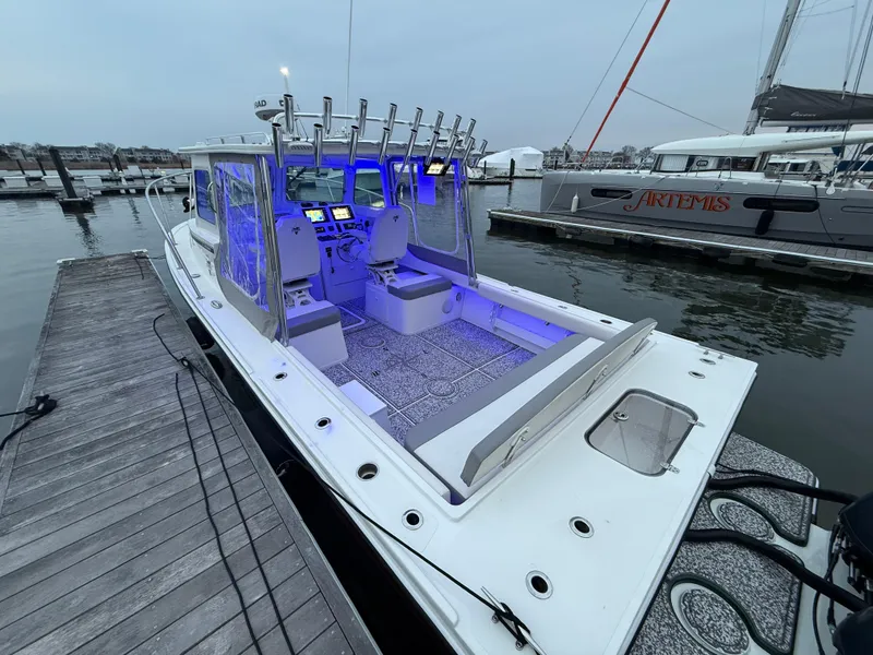 Slide: The Image of 2024 Steiger Craft 28 Peconic boat docked, featuring illuminated interior and fishing rod holders. - 4