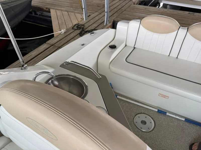 Slide: The Image of 2009 Sea Ray 240 Sundancer interior with seating and sink, docked at marina. - 14