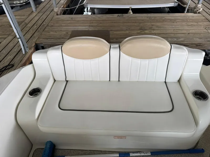 Slide: The Image of 2009 Sea Ray 240 Sundancer boat seat with white upholstery and cup holders. - 15