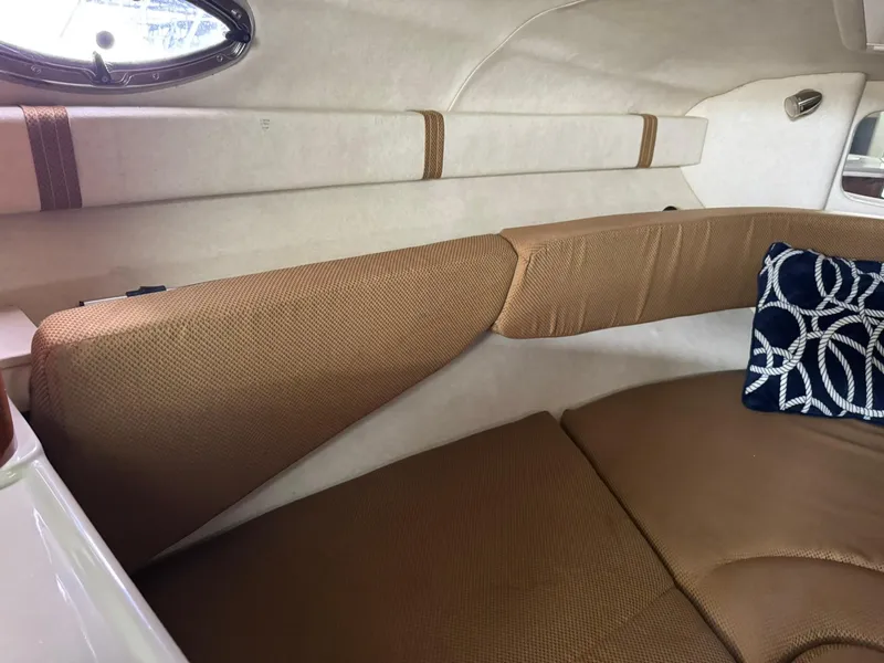 Slide: The Image of 2009 Sea Ray 240 Sundancer cabin interior with beige seating and decorative pillow. - 28