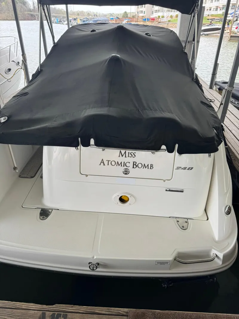Slide: The Image of 2009 Sea Ray 240 Sundancer boat docked, covered with black tarp, named "Miss Atomic Bomb." - 9