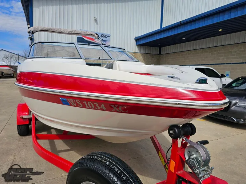 Slide: The Image of 2010 Larson Senza 186 boat on trailer, red and white design, parked outdoors. - 13