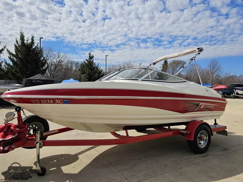 Slide: The Image of 2010 Larson Senza 186 boat on trailer under a partly cloudy sky. - 18