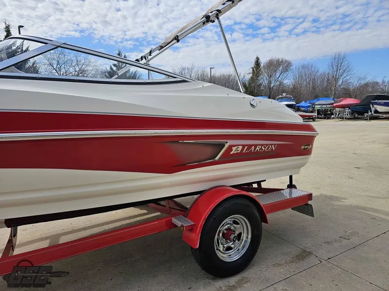 Slide: The Image of 2010 Larson Senza 186 boat on a red trailer, parked outdoors. - 20