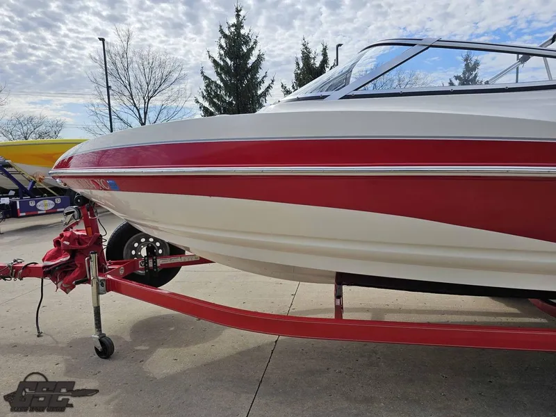 Slide: The Image of 2010 Larson Senza 186 boat on trailer, red and white design, parked outdoors. - 21