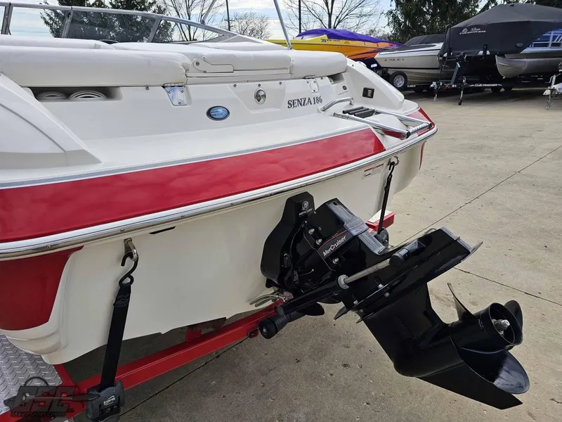 Slide: The Image of 2010 Larson Senza 186 boat with red and white exterior, displayed in a marina. - 25