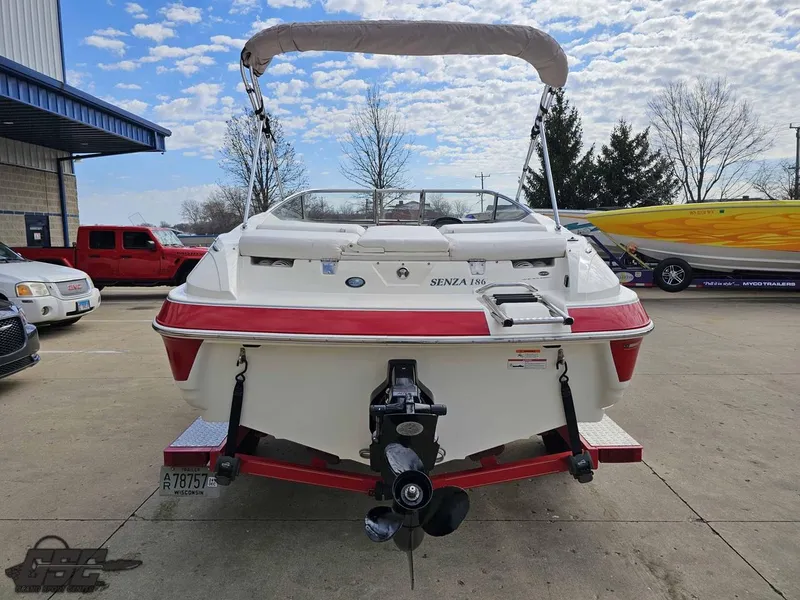 Slide: The Image of 2010 Larson Senza 186 boat, rear view, parked outdoors under a partly cloudy sky. - 26