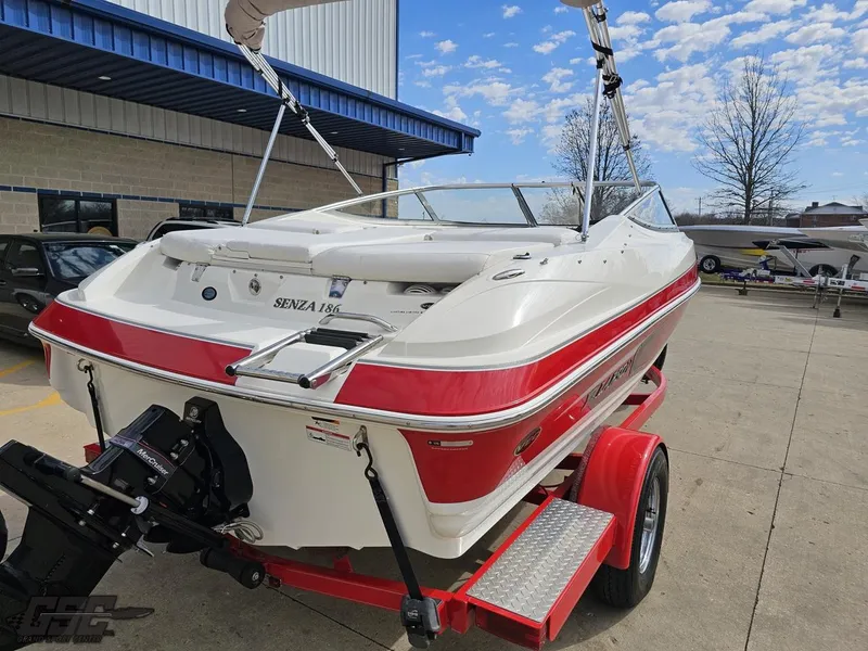 Slide: The Image of 2010 Larson Senza 186 boat on trailer, red and white design, parked outdoors. - 29