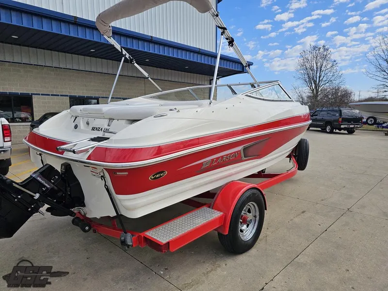 Slide: The Image of 2010 Larson Senza 186 boat on red trailer, parked outdoors. - 30
